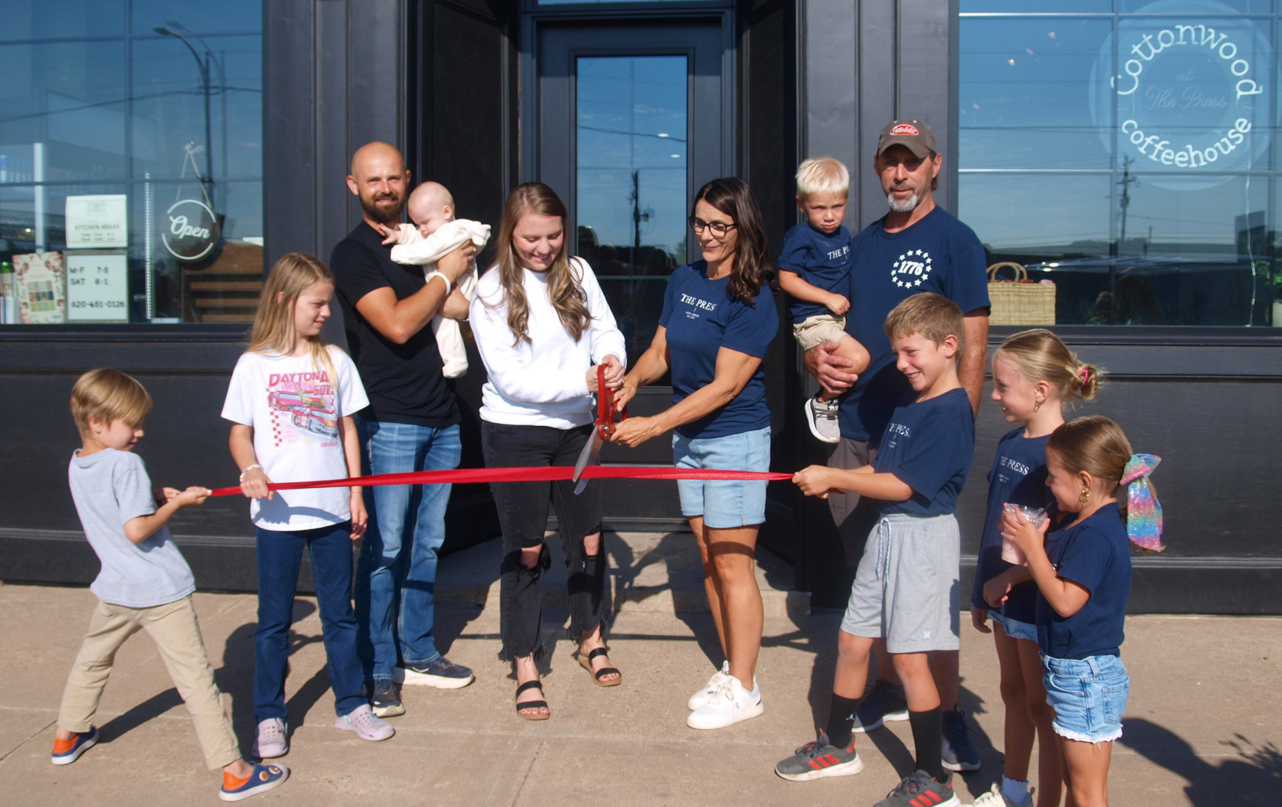 Above: Surrounded by their families, Enny Teichroeb (center left) and Aimee Burch cut the ribbon to celebrate the Grand Opening of Cottonwood Coffeehouse at The Press. Left: A view inside. Below Left: Part of the rear patio. See more photos on page 8.