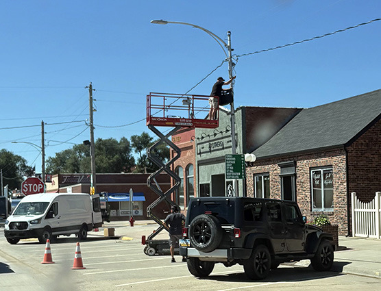 Workers with Parr Sound and Lighting install the new Main Street Sounds project speakers.