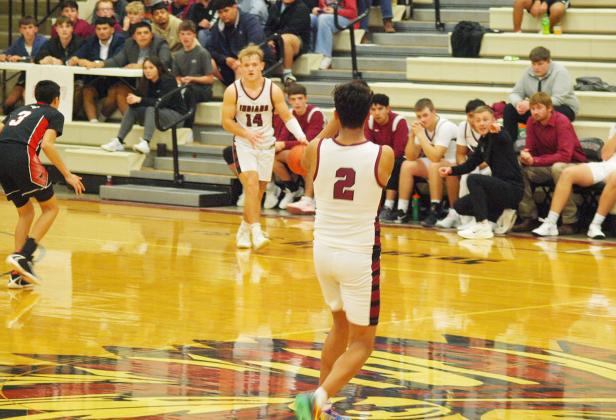 Cashton Young, 14, prepares to pass to Christian Figueroa, 2, as Coach Rietzke signals.