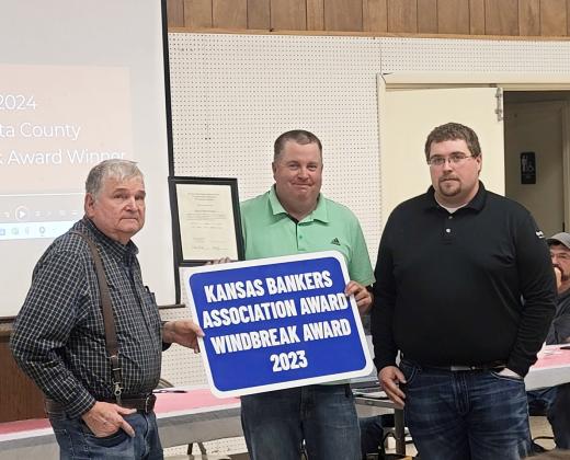 Tony Harkness and Brian Harkness of Harkness Repair, LLC, are presented with the Kansas Bankers Association Award 2023 Windbreak Award at the 76th Annual Meeting of the Wichita County Conservation District, held January 29, 2024, at the Community Building. Presenting the sign and plaque to the father/son duo is Tristan Perry of Security State Bank. Photo courtesy Darla Lewis