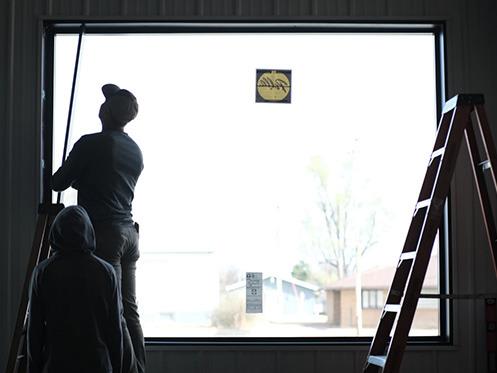 Casey Venters and his son measure wood used in the windows of the store being built in Dighton, Kansas. Calen Moore/Kansas News Service
