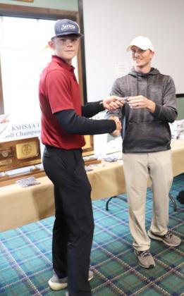 Above: Colton Harbin received his recognition and handshake from a KSHSAA official after placing ninth at the State Golf Championship Tournament.