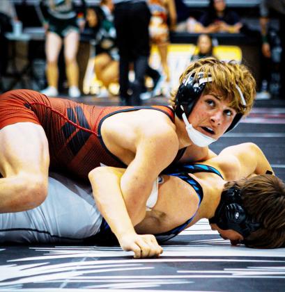 Above: Tayson Guerra wrestles in his 113 lb weight class at the State tournament.