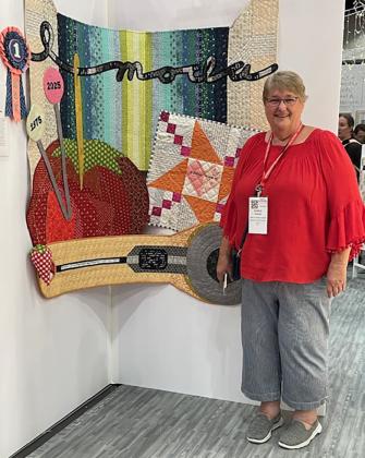 Krenzel poses with quilt at Quilt Market in Houston.