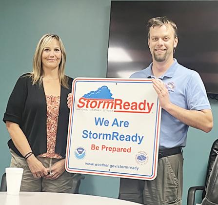 Above: Jesse Lundquist (NWS-Goodland) presents the Very Large Sign to Mindi Bremer, RN, EPM, SO. Provided