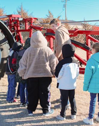 Below: Quentin Koehn with students from Mrs. Budde's First Grade Class.
