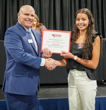 At Right: Bruce W. Mueller (left), CEO/general manager of Wheatland Electric Cooperative, Inc., recognizes Sophia Wedel (right), a junior from Wichita County High School, at WEC’s annual meeting in Scott City. Wedel was selected to represent Wheatland Electric Cooperative, Inc. (WEC) at this year’s Electric Cooperative Youth Tour in Washington, D.C.