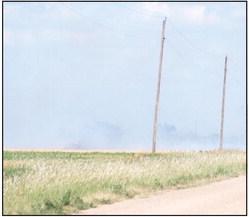 Smoke obscures the firefighters and the farmhouse.