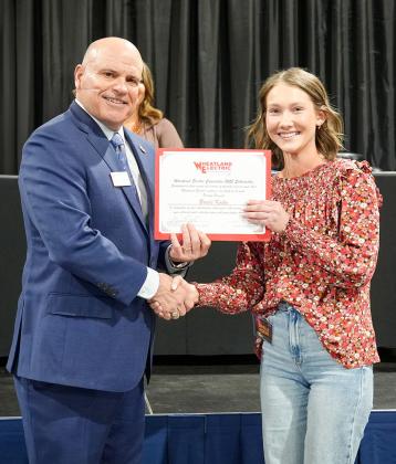 Bruce W. Mueller (left), CEO/general manager of Wheatland Electric Cooperative, Inc., awards Brielle Koehn (right), senior at Wichita County High School, with a $1,000 scholarship during WEC’s annual meeting in Scott City, Kan. on April 23.