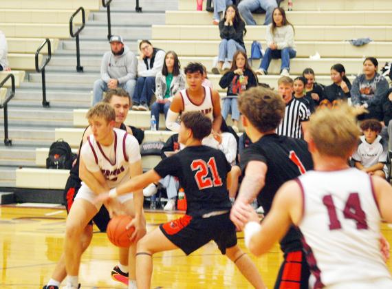 Chase Carpenter (13) is determined to keep possession of the ball, despite his opponent's efforts.