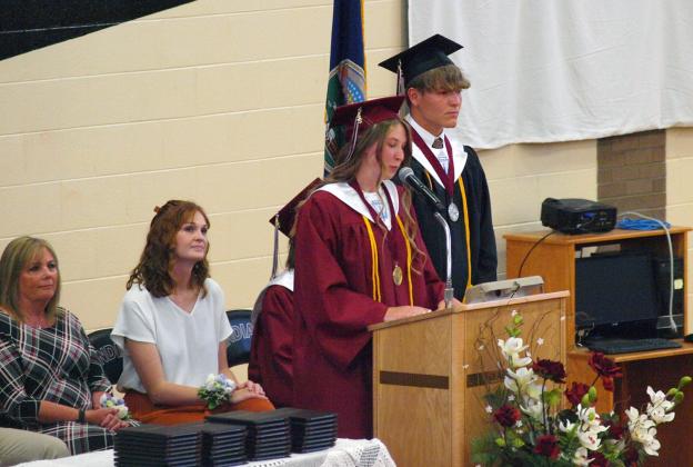 Valedictorian Clara Koehn speaks to the class as (L-R) Superintendent Lori Maxwell, Nicole Fischer, and Salutatorian Max Whitham listen carefully.