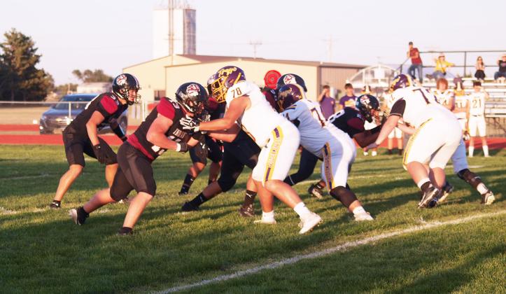 In the foreground, the Indians Tadyn West (13) blocks, Max Whitham (33) prepares to make a move. On the far side of the field, Khris Hermosillo (28) may be carrying the ball into defenders.