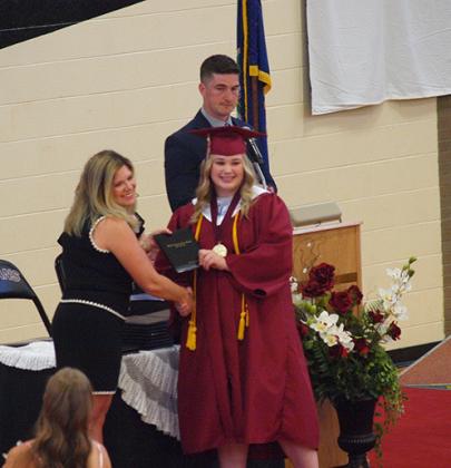 Valedictorian Delaney Biel accepts her diploma from BoE president Eryka Smity
