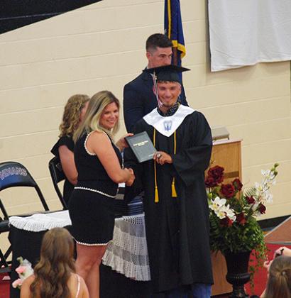 Dylan Luna accepts his diploma from BoE president Eryka Smith