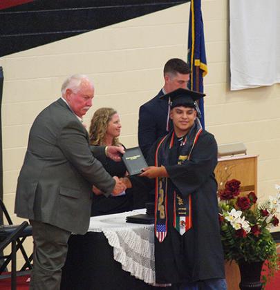 Pablo Reyes II accepts his diploma from BoE member Farrin Watt