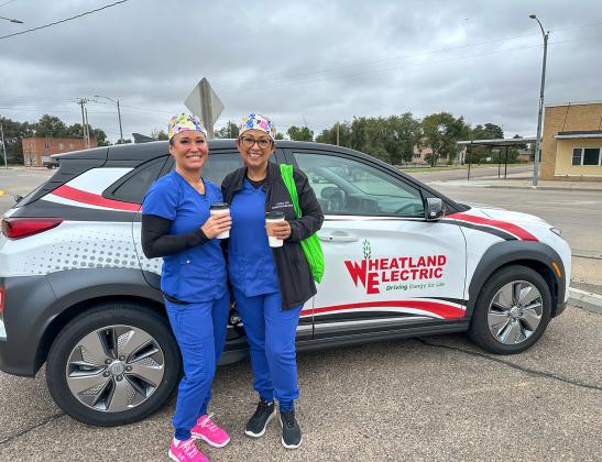 Attendees at Wheatland Electric’s EVs &amp;amp; Espressos event in Leoti pose with the Hyundai Kona Electric after completing a test drive of the all-electric vehicle on October. 8, 2025.