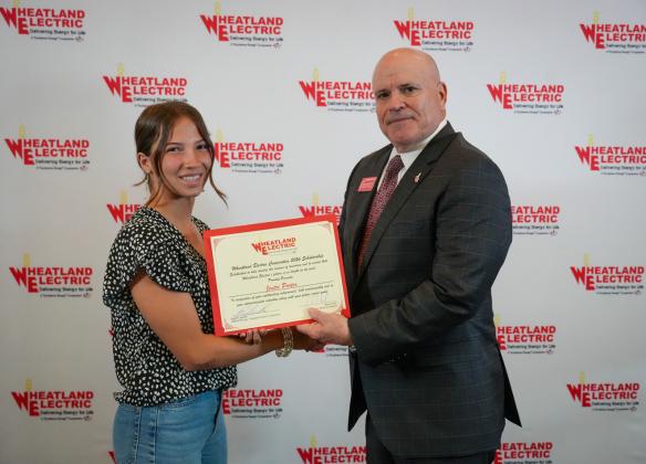Bruce W. Mueller (right), CEO/general manager of Wheatland Electric Cooperative, Inc., awards Jentri Porter (left), a senior at Wichita County High School, with a $1,000 scholarship during WEC’s annual meeting in Great Bend, Kan. on April 22.