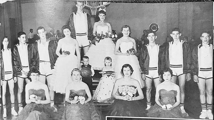 [ Above:] Sara Herndon reigns as Wichita County Community High School cage queen at Leoti. Pictured with her are JoEllyn Jaeger, Carol Seibel, Donna Wewer, Loula Mae Schwindt, Phyllis Humble, Alice Pfeifer, Delbert Harkness, Rolly Brown, Eddie Kessler, Capt. J.R. Royer, Jerry Hooker, Larry Schwindt, and Larry appl. Tiny attendants bearing the insignia of authority in the extravaganza are Gary Wewer and Kim Green.