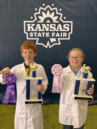 Pictured: Reid Marcy (left) and Lyvia Imler (right) proudly display their Grand and Reserve Champion trophies from the Kansas State Fair Rabbit Showmanship Contest.