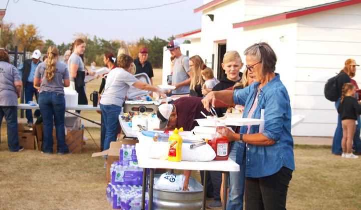 Above and Below: Hungry game-goers take advantage of the tailgate meal provided by Security State Bank.