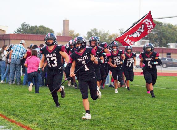 The Indians take the field through a crowd of supporters.