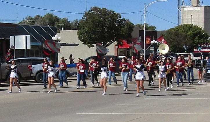 The Fall Cheer Squad and the marching band lead the Homecoming Parade down 4th Street on Friday.