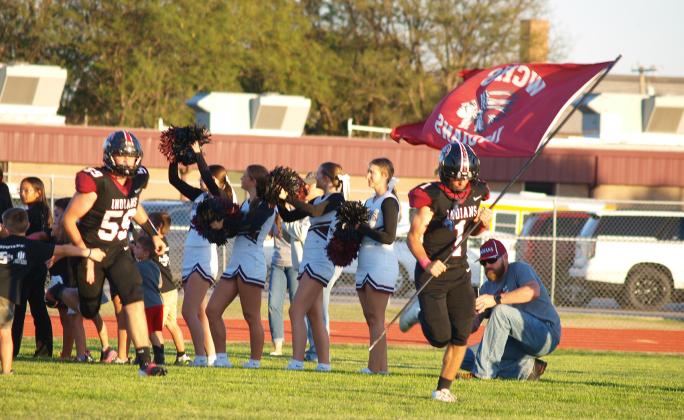 Peters (1) and Gerstberger (59) lead the varsity football team onto the field.