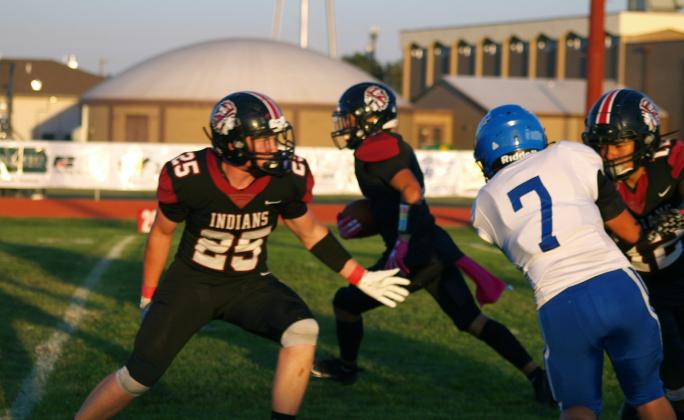 Whalen (25) and Romero (12) block for the Indians ball carrier.