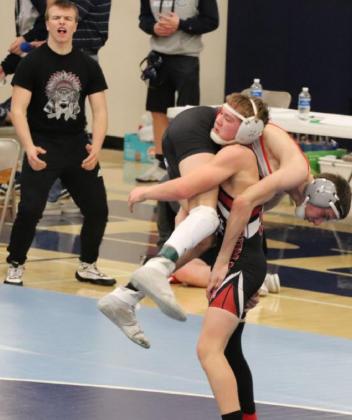 Above: Wyatt Gardner (in singlet, standing) makes a monster move during a match at the sub-state tournament in Minneapolis, KS, on Saturday, February 20, causing his older brother, Jesse Gardner (L), to erupt in a raucous cheer. Photo credit Maggie Brown
