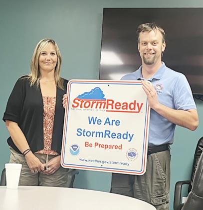 Above: Jesse Lundquist (NWS-Goodland) presents the Very Large Sign to Mindi Bremer RN, EPM, SO Provided