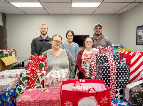 WEC employees Joshua Koester, electrical engineer (far left), and Dax Walk, district manager (far right), pose with representatives of Saint Francis Ministries in Great Bend.