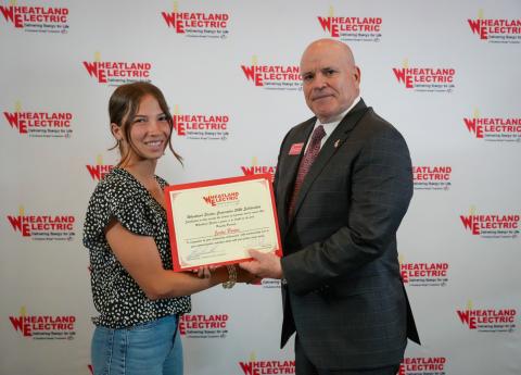 Bruce W. Mueller (right), CEO/general manager of Wheatland Electric Cooperative, Inc., awards Jentri Porter (left), a senior at Wichita County High School, with a $1,000 scholarship during WEC’s annual meeting in Great Bend, Kan. on April 22.