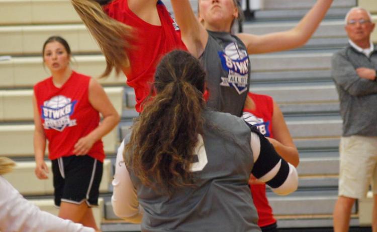 Kyra Case, in gray, tries to block her opponent’s shot.