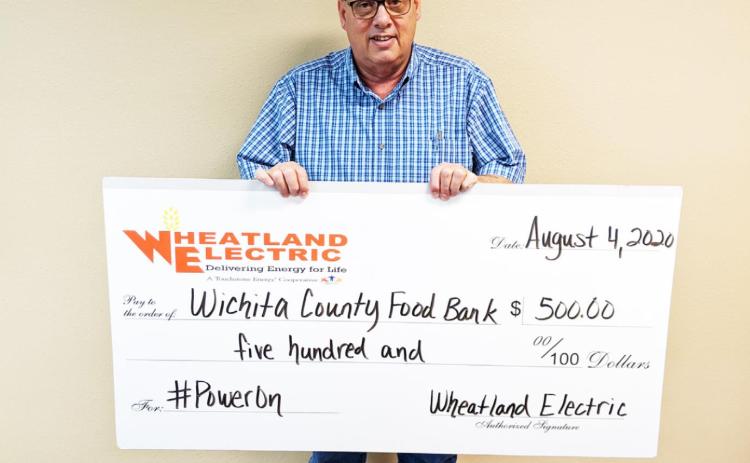 Photo: Gary Salmans from the Wichita County Food Bank poses with one of two $500 donations. The funds are aimed to assist with pantry supplies and are part of Wheatland Electric’s Cram the Van food drive and #PowerOn campaign. P h o t o courtesy Wheatland Electric