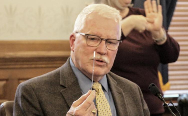 Kansas Health Secretary Lee Norman displays a swab used for COVID-19 testing. A small hospital in central Kansas has deployed blood tests that state health officials say can produce false positives among people with common colds. Celia Llopis-Jepsen/Kansas News Service