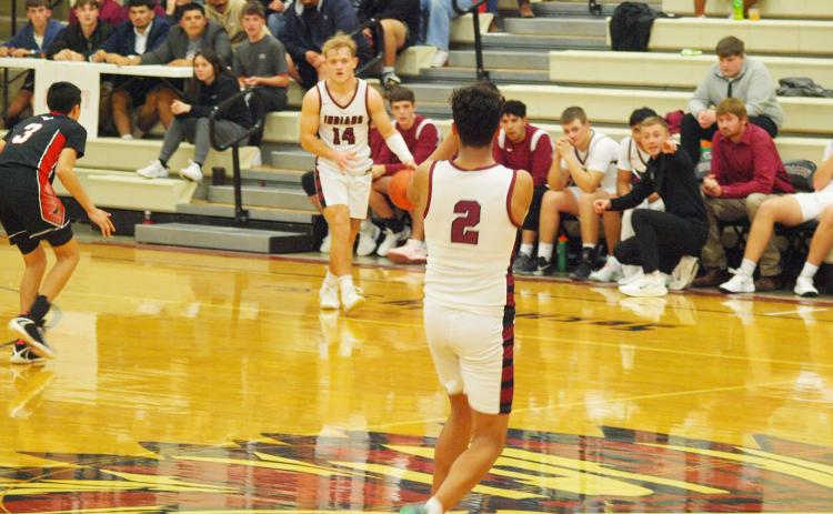 Cashton Young, 14, prepares to pass to Christian Figueroa, 2, as Coach Rietzke signals.