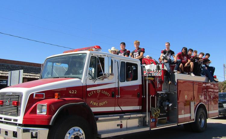Members of the high school football team catch a ride on a fire truck for the Fall Homecoming Parade, held Friday, September 23.