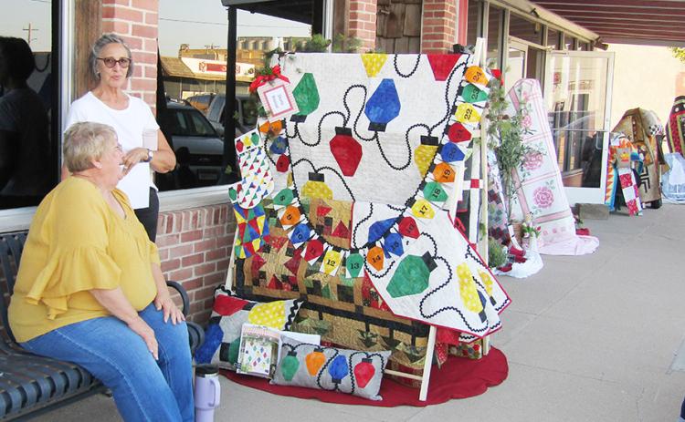 Above: Quilt Guild members Sharla Krenzel and Kathy Mullen display a large assortment of quilts. Below: A recently departed member of the community, Billie Biel, is lovingly remembered.