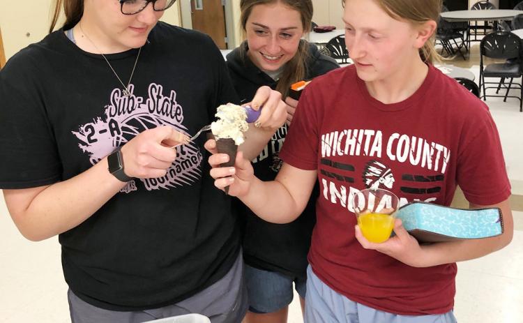 The ice cream bucket says it all! Sydney Biermann and Addy and Anna Simons prepare an ice cream cone at the conclusion of the final High School Youth Group session for St. Mary and St. Anthony of Padua students for this year. More than 20 young people from both parishes participated in a weekly Wednesday night Bible study this past year. This week the youth played several spirited rounds of Bingo, with gift cards from Subway and Leoti’s Daily Dose coffee shop as prizes.