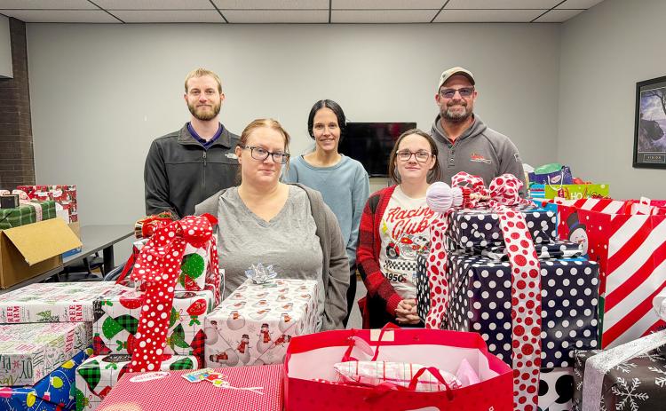 WEC employees Joshua Koester, electrical engineer (far left), and Dax Walk, district manager (far right), pose with representatives of Saint Francis Ministries in Great Bend.