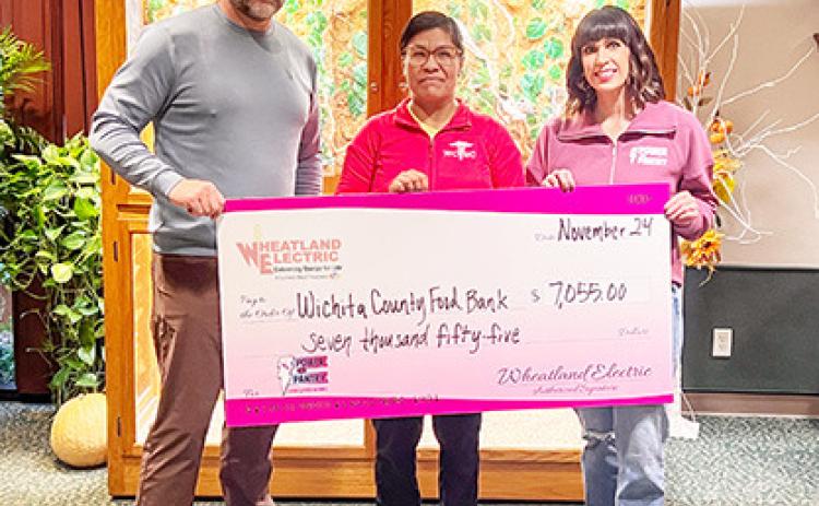 Alli Conine (right), director of member services and corporate communications at Wheatland Electric, and Josh Young, trustee (left), present a check for $7,055 to Mirna Jimenez (center) of the Wichita County Food Bank. Provided