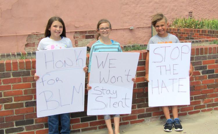 Kimberly Meyer, 11, Abbey Meyer, 10, and Luke Meyer, 7, demonstrated in front of the newspaper office.