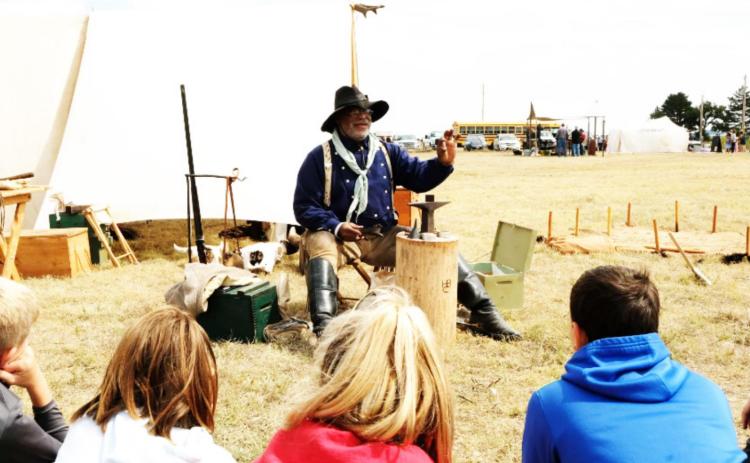 Henry Crawford demonstrates to Wallace County schoolkids during a field trip in September how to load the antique cartridges once used for buffalo hunting on the Kansas plains. Esther Honig/For the Kansas News Service