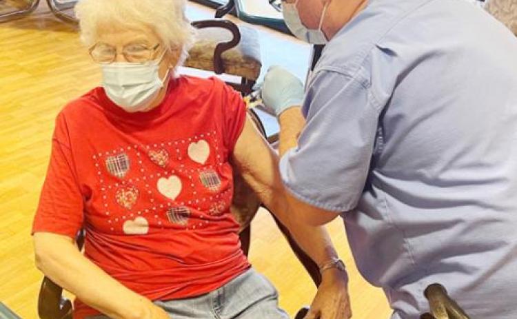 Pictured left, Lois Wiles receives her first dose of the Moderna vaccine.