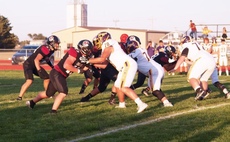 In the foreground, the Indians Tadyn West (13) blocks, Max Whitham (33) prepares to make a move. On the far side of the field, Khris Hermosillo (28) may be carrying the ball into defenders.
