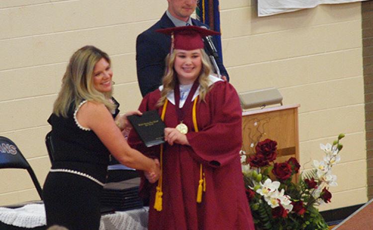 Valedictorian Delaney Biel accepts her diploma from BoE president Eryka Smity