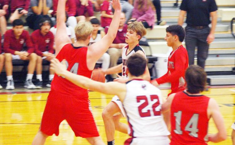 Above: Cordell Brown (22) fends off a Larks defender as Colton Harbin drives to the net.