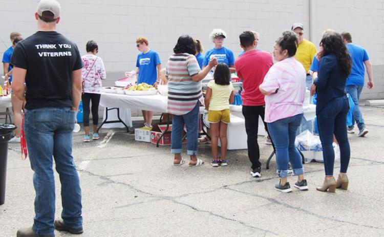 Above: Patrons line up for the 25th anniversary free lunch, served Wednesday, July 27.