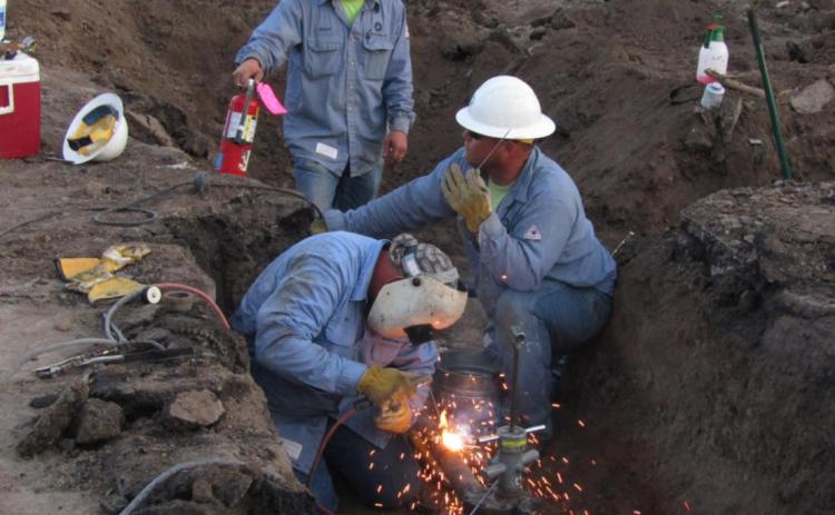 Workmen repair a gas pipeline