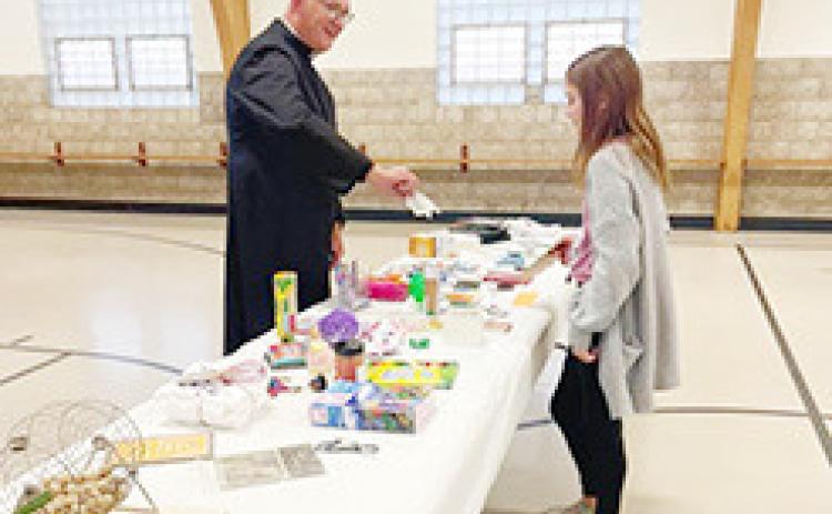 Above: Katelyn Price, daughter of Matt and Heather Price, reviews the prize table with Father Tim S. Hickey, after winning the first round of bingo at the Pastor Appreciation Night, jointly sponsored by the Social Action Committees of St. Anthony of Padua and St. Mary parishes at St. Mary’s School gym Saturday Oct. 8. In addition to several intense rounds of bingo ( below), parishioners feasted on appetizers, pie and Octoberfest beers. (Photos courtesy of Tara Biermann)